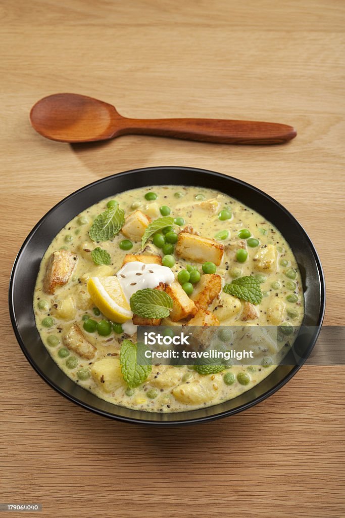 Indian Meal Food Cuisine Vegetarian Curry Panir and Peas "Vegetarian curry, panir and peas, garnished with mint, lemon and yoghurt, in a black bowl on a wooden table. More curry" Black Color Stock Photo