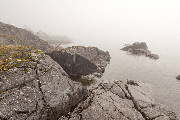 istock Fog on stony coast of lake.  spring landscape 179064940