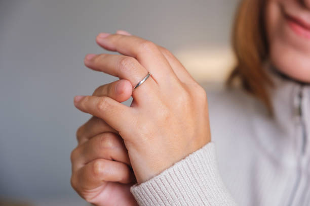 istock Closeup image of a woman putting on a silver ring on her ring finger 1790654719