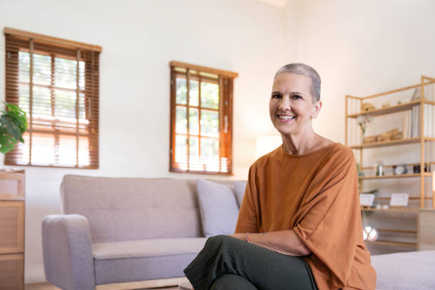 portrait d’une femme âgée caucasienne souriante heureuse assise sur le canapé à la maison - demisemiquaver photos et images de collection