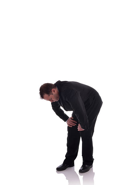 Out of breath man bent over on a white background stock photo