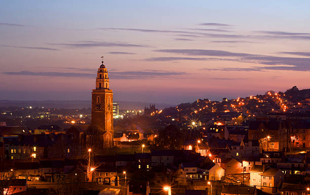 St. Anne's Church, Shandon, Cork Cork, Ireland - March 29, 2012: St. Anne's in Shandon and the City of Cork photographed against a beautiful sunset at dusk. county cork stock pictures, royalty-free photos & images