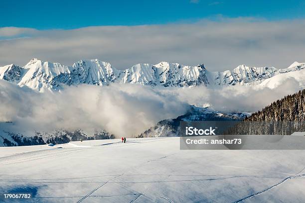Vista Panorámica A Las Montañas Y Dos Personas A Foto de stock y más banco de imágenes de Megève - Megève, Esquí - Deporte, Abeto