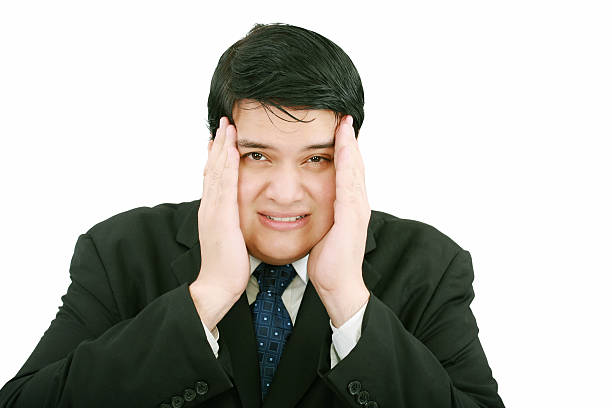 istock businessman with a migraine holding his temples. 179068752