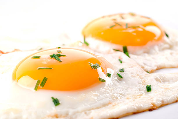 Two fried eggs with chive on top.