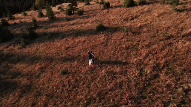 Authentic wedding couple walking through the mountains in autumn at sunset.Wedding concept in the mountains.Cinematic frame 4k