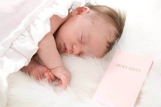 istock Precious Newborn Baby Sleeping Peacefully with Bible 179070316