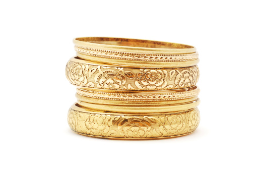 golden bracelets on white background