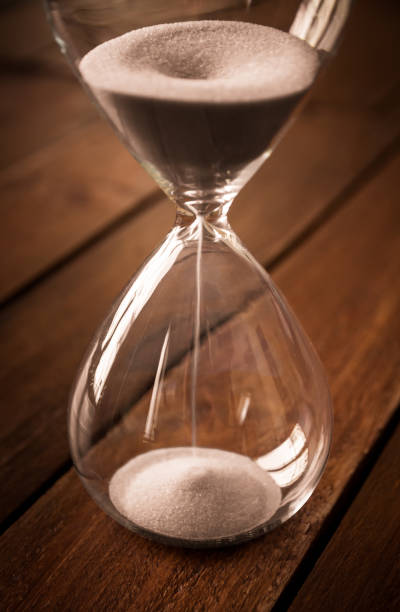 istock Hourglass containing white sand on a rustic wooden board 1790712746