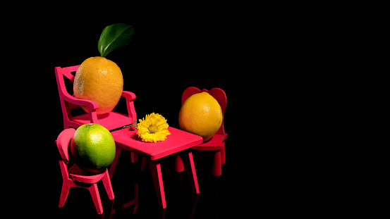 Creative still life with three lemons at the table with a flower on a black background