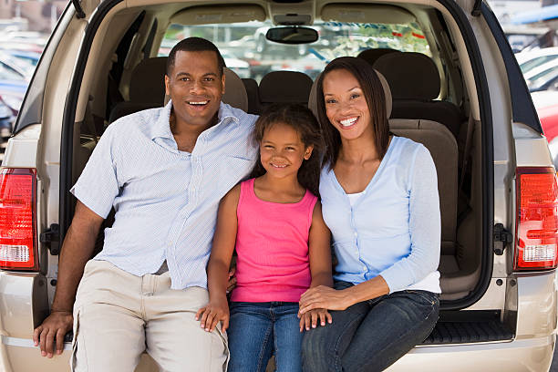 Family sitting in back of van smiling Family sitting in back of van smiling. Looking at camera. family-van-driving stock pictures, royalty-free photos & images