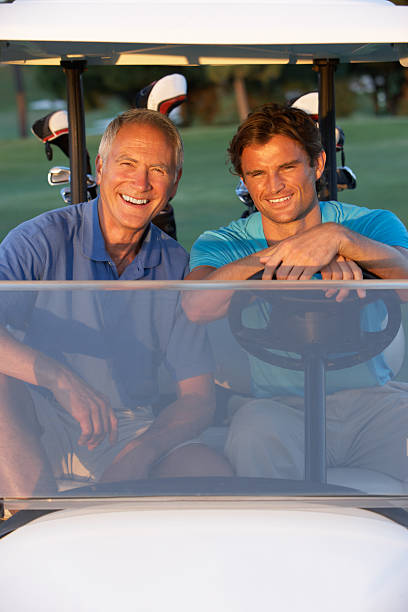 dois ciclistas golfers dirigindo em buggy de golfe - golf course golf people sitting imagens e fotografias de stock