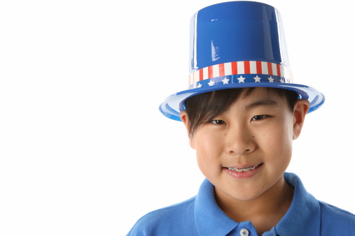 Patriotic Asian American boy wearing a tophat with stars and stripes.