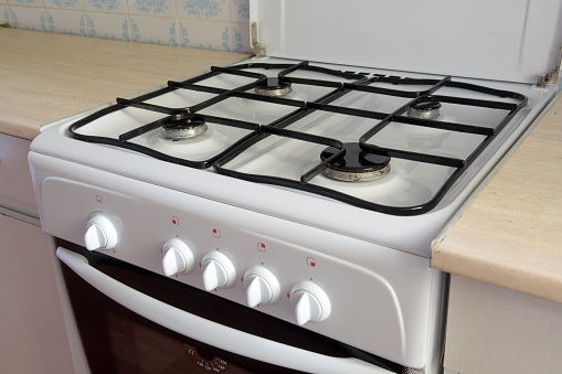 gaz range in kitchen with pan on it, shallow DOF, focus on pan