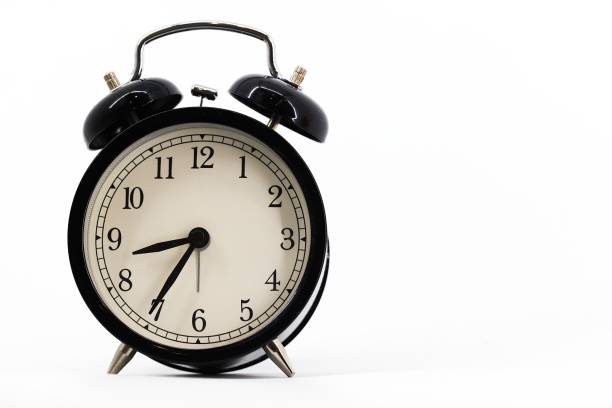 istock A black alarm clock with two bells on top, chrome handle, and legs, set against a white background. Timeless design meets functionality in this sleek, monochromatic timepiece. 1790750615