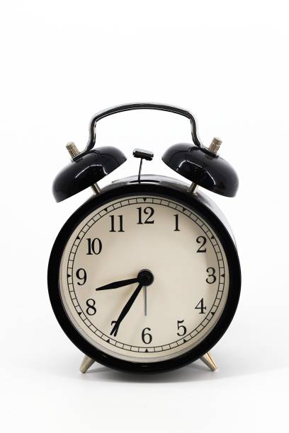 istock A black alarm clock with two bells on top, chrome handle, and legs, set against a white background. Timeless design meets functionality in this sleek, monochromatic timepiece. 1790750617