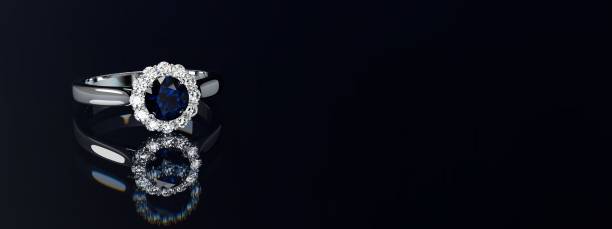 istock Halo diamond engagement ring with a round sapphire on black glossy background. Wide image 1790756522