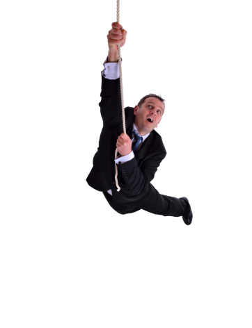 image of a businessman hanging on a rope. Isolated on white