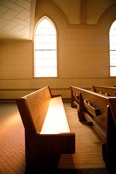 istock Church pews with a stained glass window and light showing 179076971