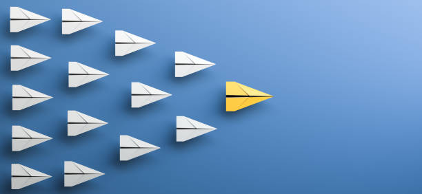 Leadership concept, yellow leader plane leading white planes, on blue background with empty copy space on right side stock photo