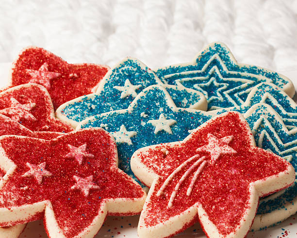 Red and Blue Cookies on a White Background Yummy sugar cookies in Red and Blue sprinkles are placed on a white background.  The cookies have shooting stars and multiple stars on them.  Perfect image for summer holidays! white sugar cookie stock pictures, royalty-free photos & images