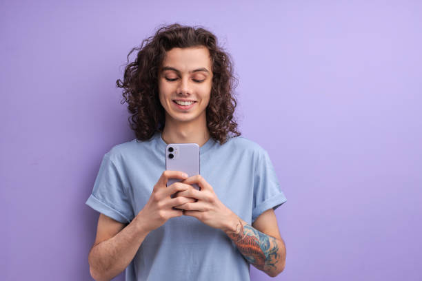 istock Glad cheerful cheery guy using cell comment feedback repost smm service isolated over bright vivid shine vibrant purple color background 1790793481