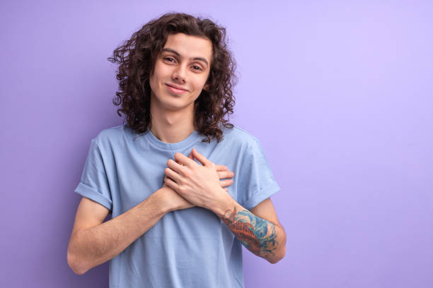 istock Handsome pleasant guy with curly hair keep hands on chest, male is grateful for everything 1790793490