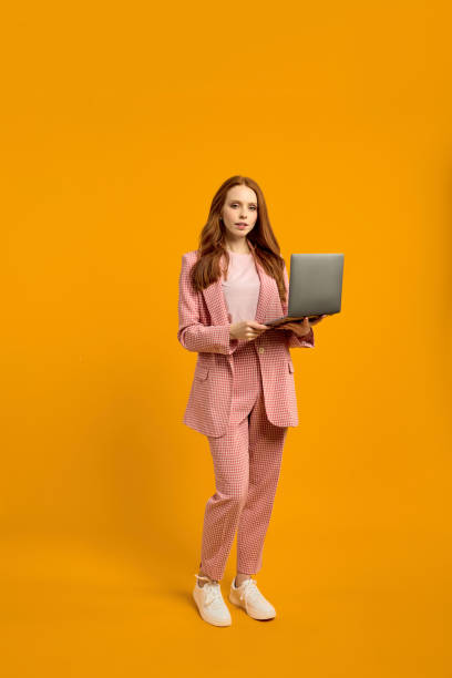 istock Confident caucasian pretty elegant foxy ginger redhaired lady walking carrying laptop 1790796185