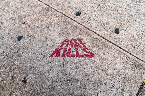 New York , NY, USA 11-09-2023 Art That Kills stenciled onto the sidewalk of a Soho New York City street. Sidewalk has texture and city wear and tear, red letters are centered, no people with copy space. Editorial use only.