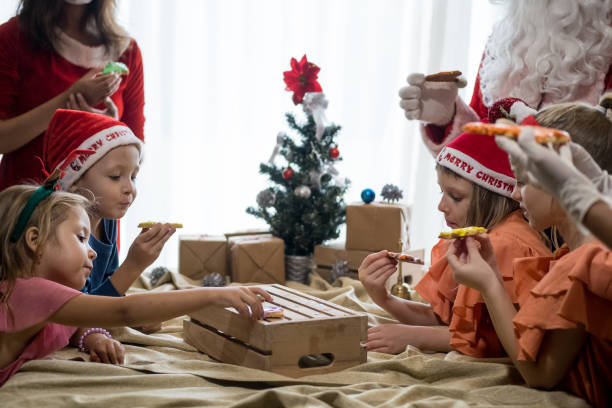 istock Children decorating Christmas biscuits and gingerbread cookies in kitchen together with chef, Santa Claus and Mrs. Claus. Kids cooking class. Merry Christmas and happy holidays 1790804401