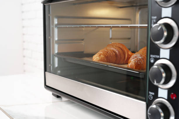 istock Modern mini electric oven with freshly baked croissants in kitchen 1790807947