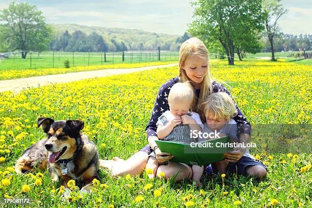 Mother Reading Book To Children Outside Stock Photo - Download Image Now - Reading, Child, Picture Book