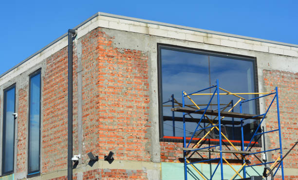 istock Modern brick house under conctruction with flat roof, panoramic windows, rain gutter pipeline, security camera. 1790814420