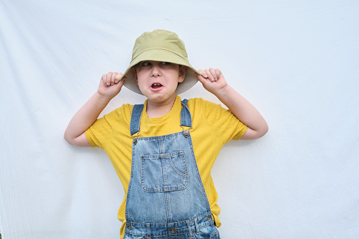 A radiant boy in a yellow T-shirt and denim jumpsuit symbolizing the joy and delight found in kid-friendly food products