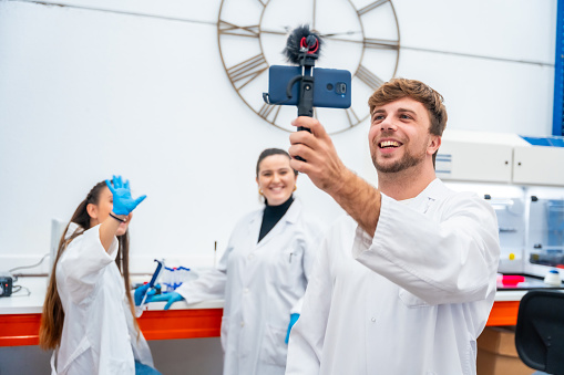 Team of scientists recording a video using phone inside a lab