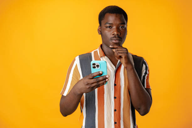 istock Young african man using smartphone againast yellow background 1790814786