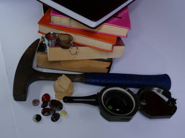 istock Geological fieldwork tools such as Brunton Compass, geology hammer, pocket knife, magnifying glass with some minerals chalcedony and calcite 1790815003