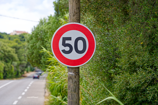 Speed limit sign 50 kilometers per hour at Giens Peninsula on a cloudy late spring day. Photo taken June 9th, 2023, Giens, Hyères, France.