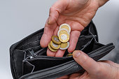 Polish PLN coins in denominations of PLN 2 and PLN 5 put into the wallet by an elderly woman