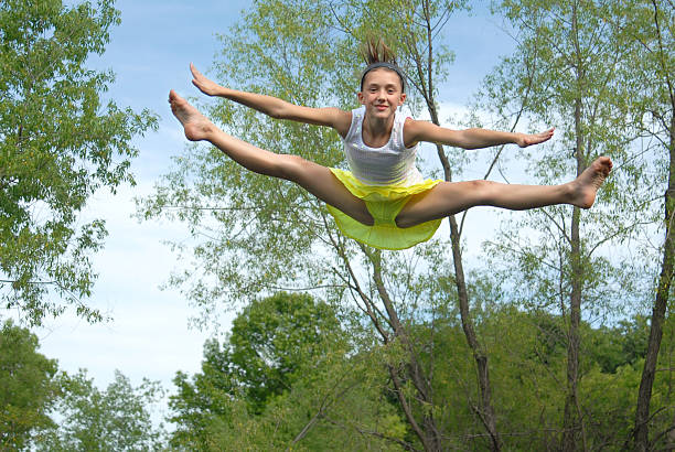 mädchen springen auf trampolin - arms outstretched teenage girls jumping flying stock-fotos und bilder
