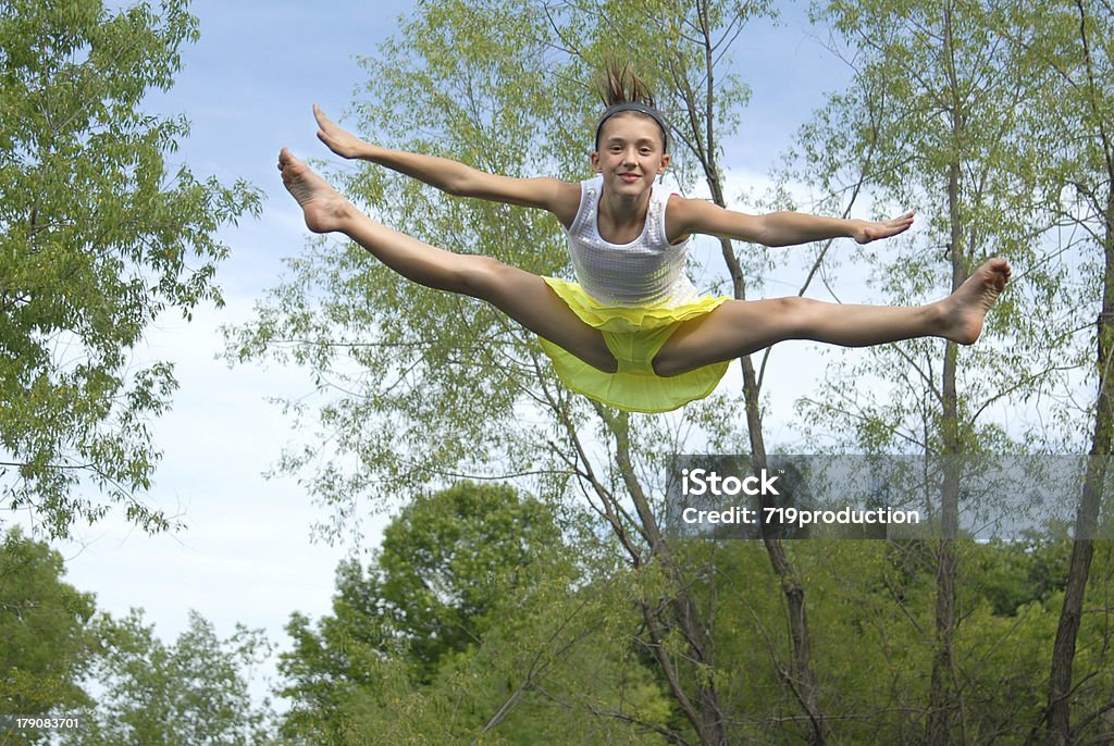 Ragazza saltando su un trampolino elastico - Foto stock royalty-free di Ragazze adolescenti