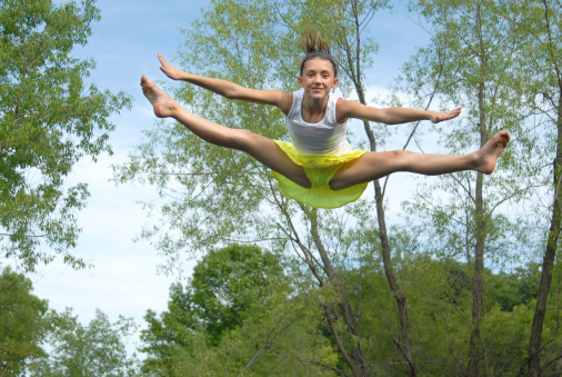 Girl in a flying position jumping on a trampoline