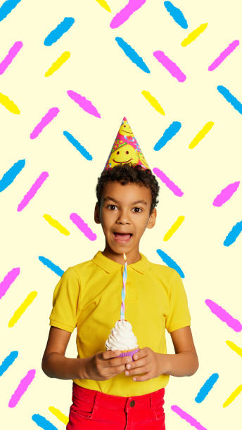istock Poster. Contemporary art collage. Modern creative artwork. Little boy holding small cupcake with cream and candle going to blow it out. 1790842371