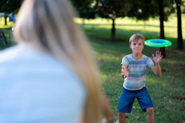 istock Boy playing whit plastic disk whit his mother in the park 1790846165