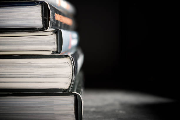 Close-up of hardbound books stacked on a black table