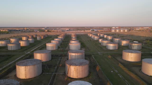 Oil storage tanks, tanks with oil, gasoline and diesel fuel. Oil refinery and storage facility. 4K video of an oil refinery shot from a bird's eye view from a quadcopter drone