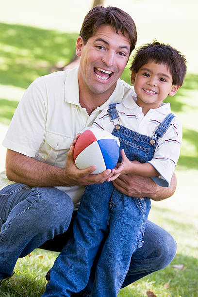 istock Man and young boy outdoors with football smiling 179085491