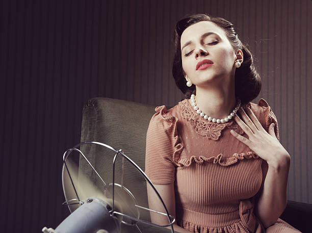 istock Woman cooling herself with fan 179085701
