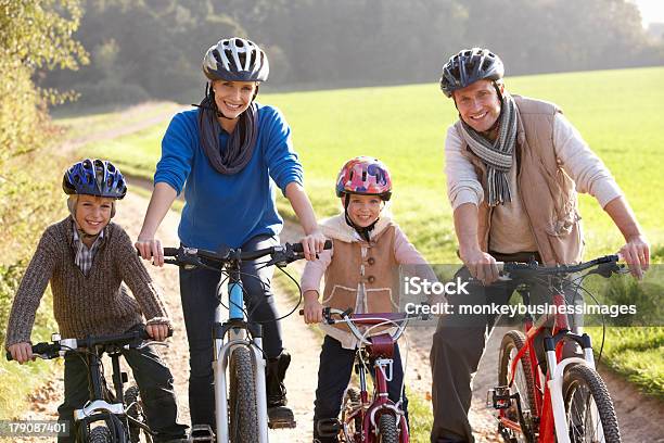 Giovane Famiglia Posa Con Bici Nel Parco - Fotografie stock e altre immagini di 10-11 anni - 10-11 anni, 6-7 anni, Adulto