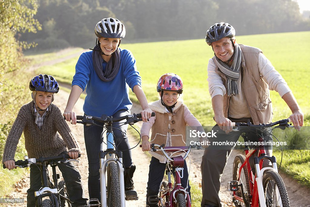 Jovem família posam com bicicletas no parque - Foto de stock de 10-11 Anos royalty-free